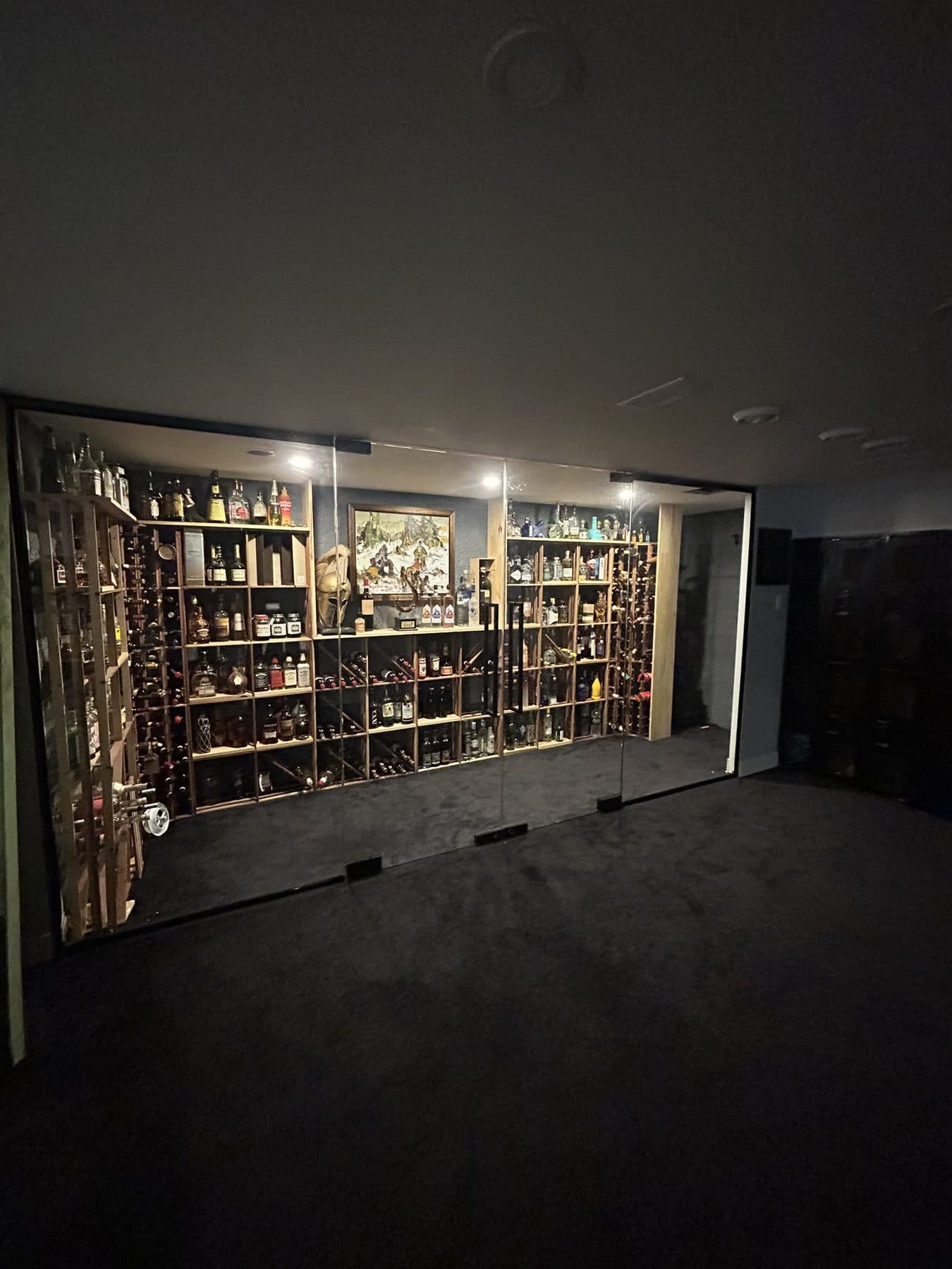Large glass wine cellar in a dark room