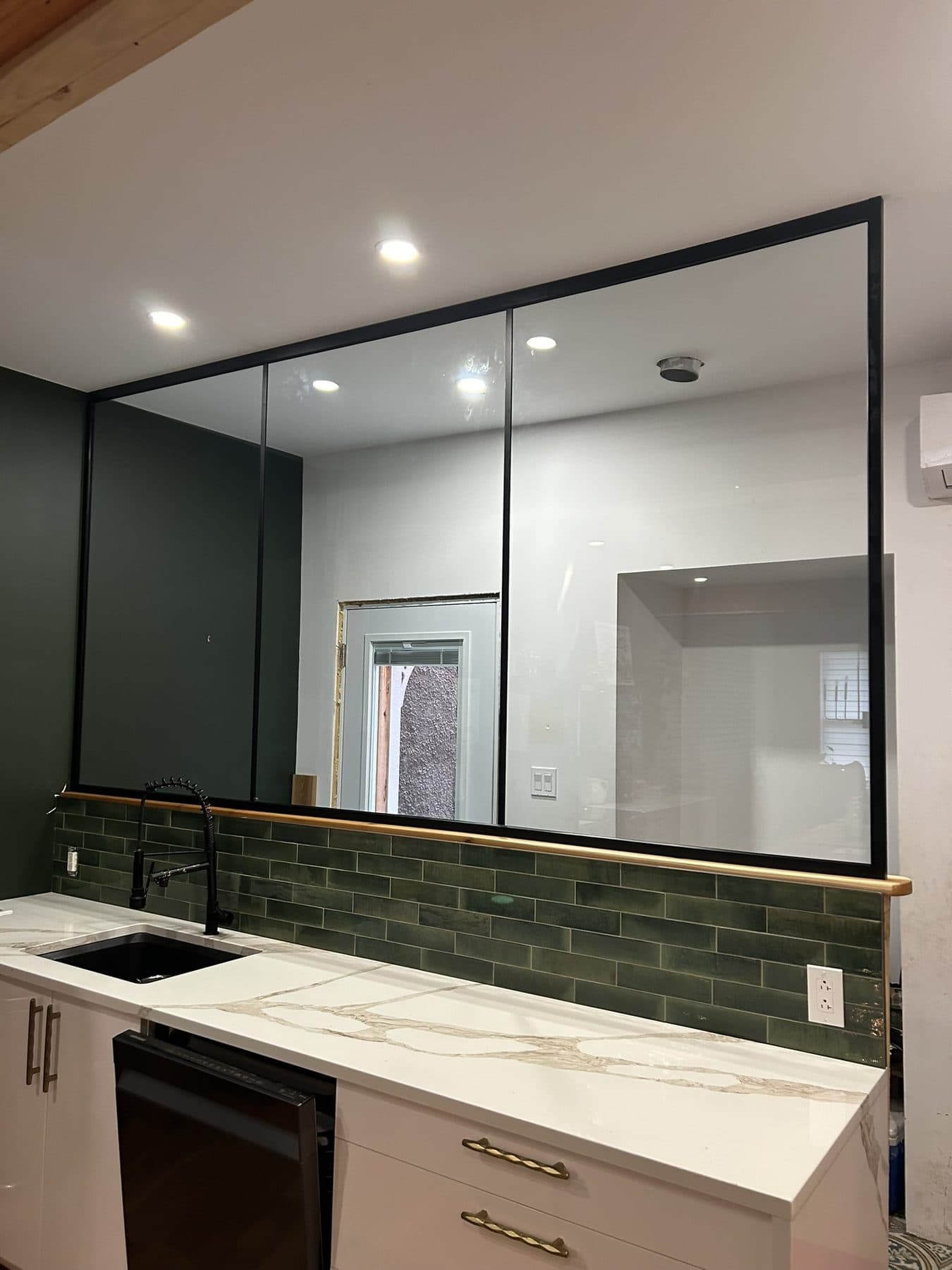 Black-frame glass wall between a kitchen and a room