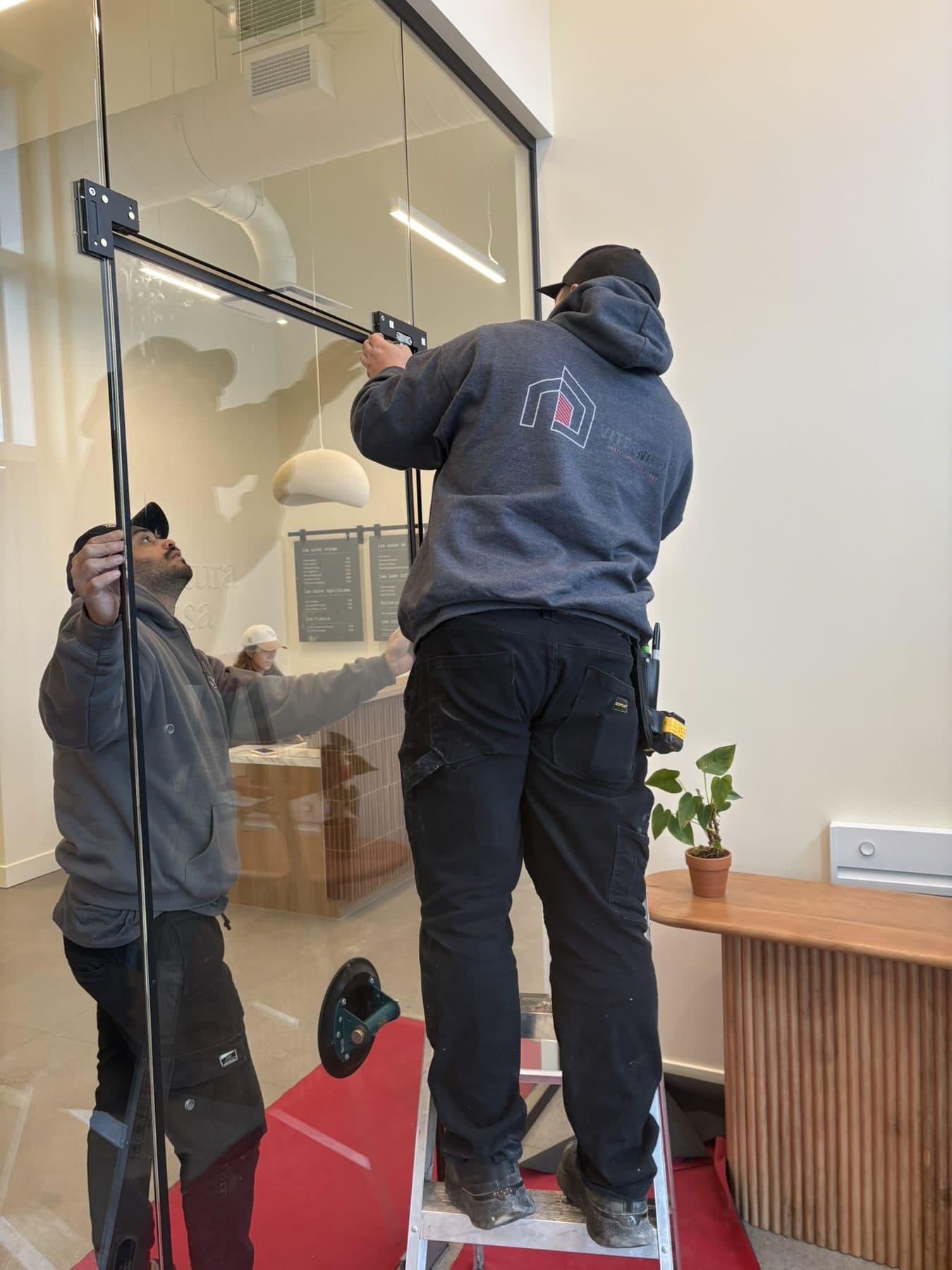 Two installers positioning a glass panel